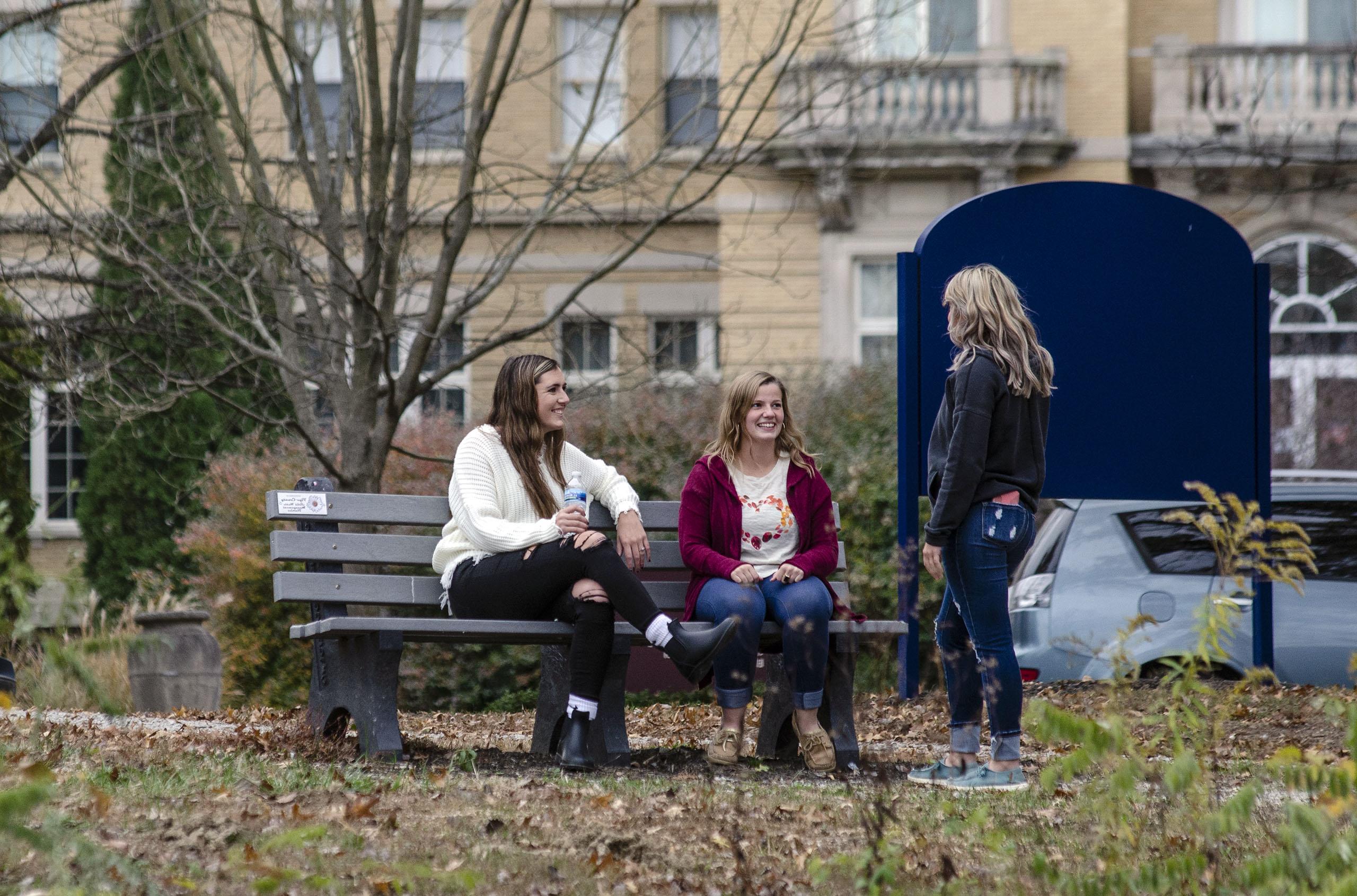 学生 on a bench in front of Le Fer Hall